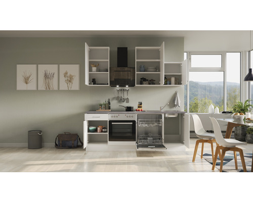 Kuchyňská linka se závěsnými skříňkami, dřezem, sporákem, troubou a myčkou nádobí ve světlé kuchyni.