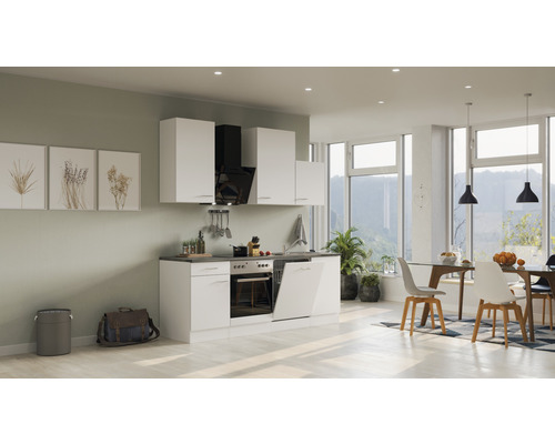 Světlá kuchyně s bílými skříňkami, digestoří a jídelním koutem se stolem a židlemi