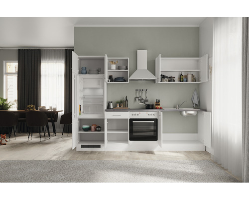 Kompaktní kuchyňská linka s dřezem, sporákem, troubou, digestoří a lednicí ve světlé místnosti.