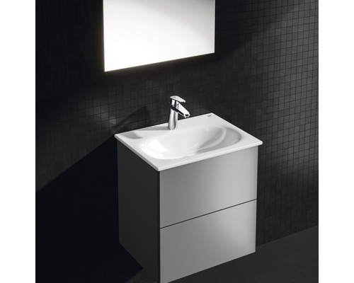 Koupelnové umyvadlo se skříňkou a baterií na tmavé zdi