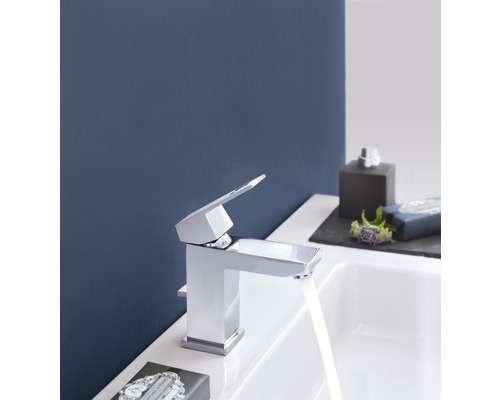 Lesklá umyvadlová baterie v koupelně s tekoucí vodou