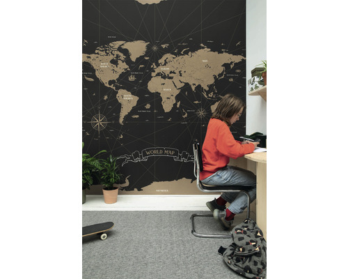 Pokoj s tapetou s mapou světa, psacím stolem a dítětem, které se učí