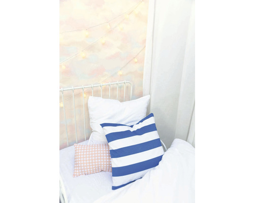 Postel s polštáři a světelným řetězem