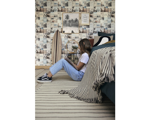 Dekorativní pokoj s fototapetou, surfovým prknem, kobercem a osobou, která čte.