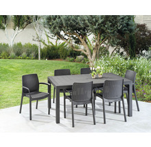 Zahradní scéna s černým zahradním stolem a šesti černými židlemi na terase se stromy v pozadí.