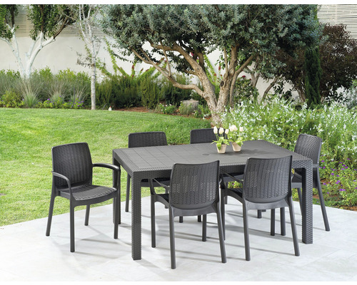 Zahradní scéna s černým zahradním stolem a šesti černými židlemi na terase se stromy v pozadí.