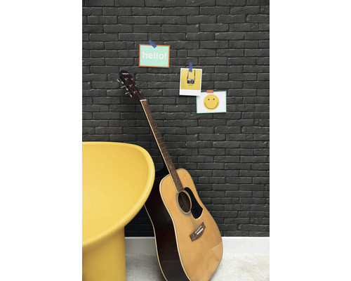 Dekorativní kamenná zeď s kytarou a žlutou židlí pro stylový interiér