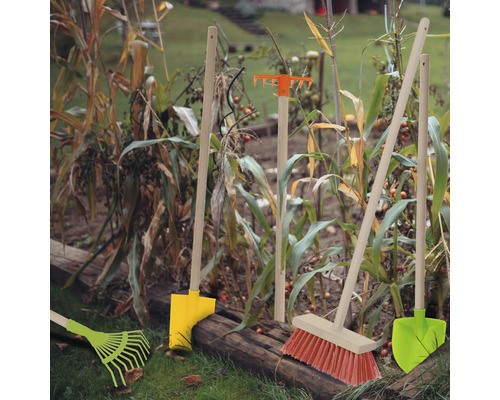 Zahradní nářadí jako hrábě, košťata a rýče v záhonu