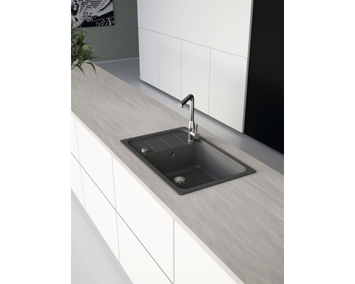 Kuchyňská scéna s dřezem a baterií v moderním designu.