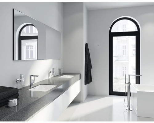 Moderní koupelna s dvojitým umyvadlem, zrcadlem a vanou.