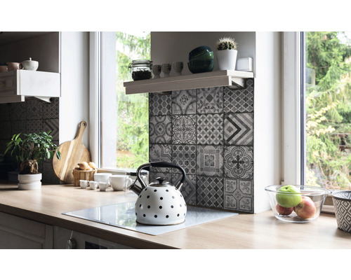 Kuchyňská scéna s mozaikovými obklady, čajovou konvicí a dřevěnou pracovní deskou