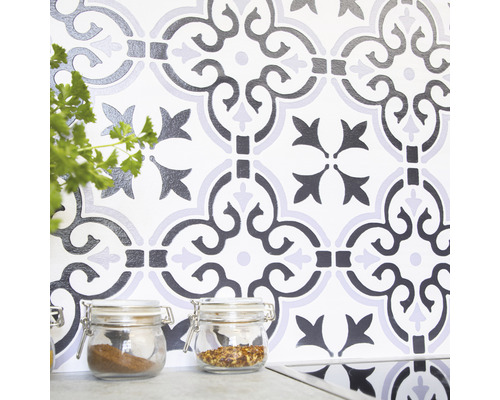Nástěnná dekorace se vzorovanými dlaždicemi a sklenicemi na koření v kuchyni