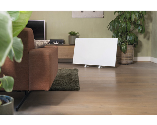 Obývací pokoj s pohovkou, pokojovými rostlinami, komodou a bílým infračerveným topným panelem.