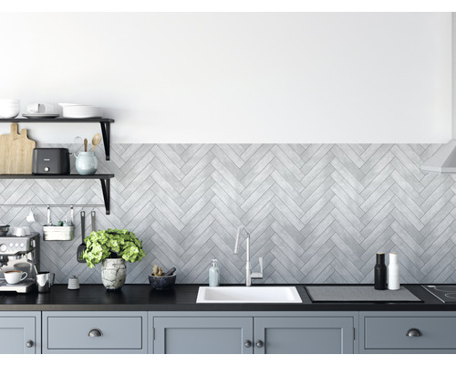 Stěnový obklad PVC Ceramics Grey Chevron 67,5x400 cm Kuchyňská scéna s dřezem, vodovodní baterií a pracovní deskou před stěnou se vzorem rybí kosti