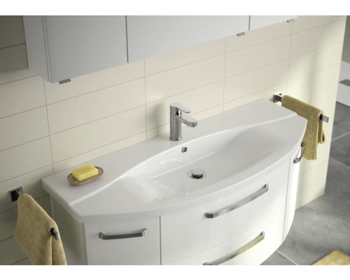 Koupelna s umyvadlovou skříňkou, baterií a držáky na ručníky.