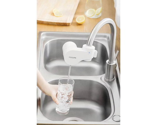 Vodovodní filtr Philips na dřezu plní sklenici vodou