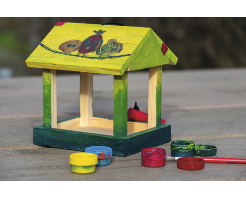 Malovaný dřevěný ptačí budka s barvami a štětcem