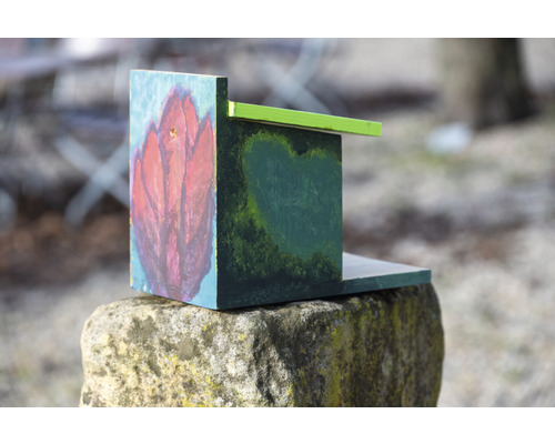 Malovaný dřevěný ptačí budka na kameni