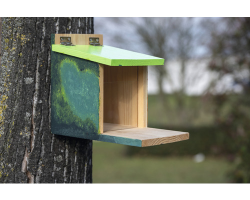 Dřevěná ptačí budka připevněná ke stromu