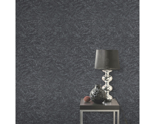 Detail šedé tapety se vzorem, stolek, lampa a váza