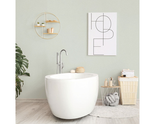 Koupelna s volně stojící vanou, nástěnnou policí, dekorací a košem na prádlo