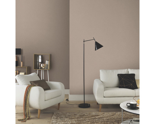 Obývací pokoj s jednobarevnou tapetou, pohovkou, křeslem a stojací lampou pro útulnou atmosféru