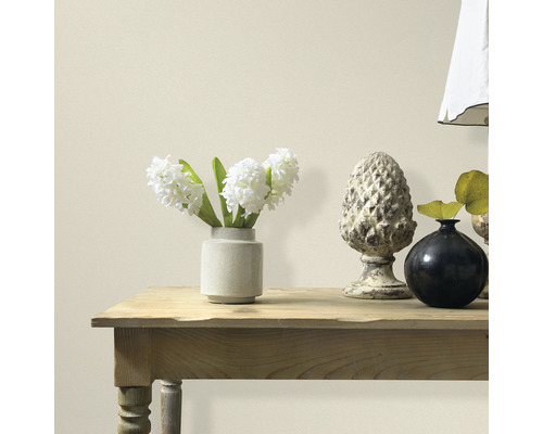 Dekorativní prvky na dřevěném stole před zdí.