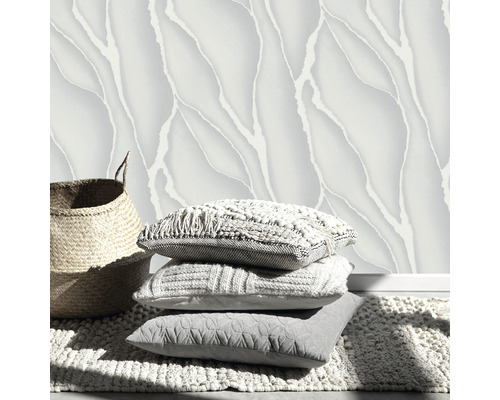 Dekorativní design stěn s vzorovanými tapetami, hromadou polštářů a košem na koberci