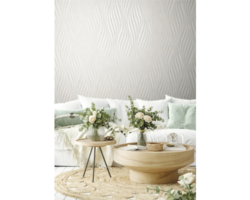 Obývací pokoj s bílou designovou tapetou, pohovkou a dřevěnými stolky na koberci