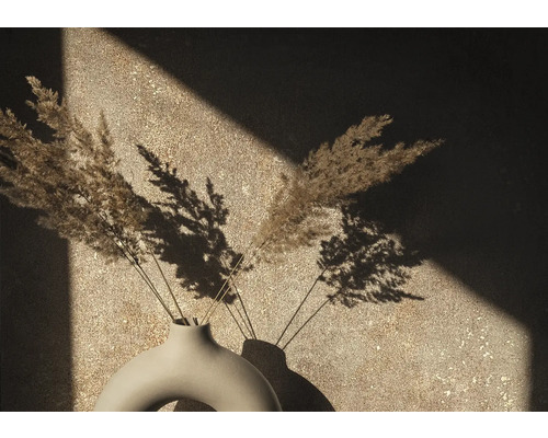 Dekorativní váza se sušenými trávami před zdí