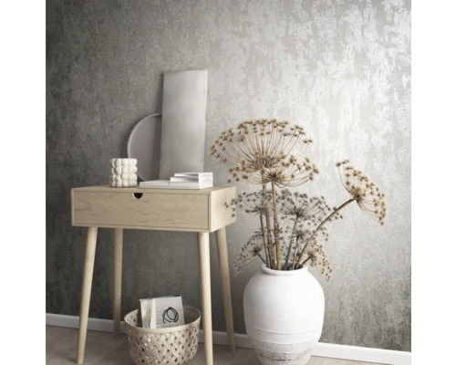 Dekorativní interiér s konzolí, vázou a sušenými květinami před strukturovanou tapetou.