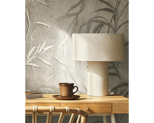 Dekorativní stěna s motivem listů, stolní lampa a šálek čaje pro útulnou atmosféru