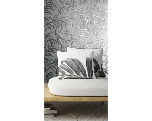 Dekorativní obývací pokoj s vzorovanou tapetou a polštáři s rostlinnými motivy na pohovce