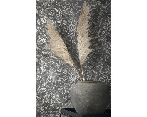 Dekorativní peří v kameninové váze před vzorovanou tapetou
