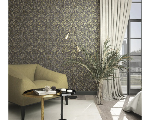 Obývací pokoj s vzorovanou tapetou, křeslem, stojací lampou a pokojovou rostlinou