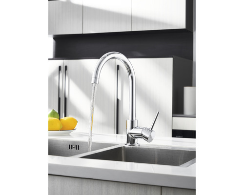 Chromovaná kuchyňská baterie s tekoucí vodou v umyvadle