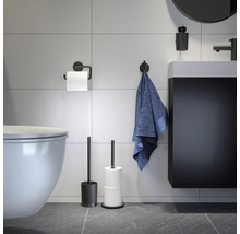 Moderní koupelna s toaletou, umyvadlem, ručníkem, držákem toaletního papíru a WC štětkou