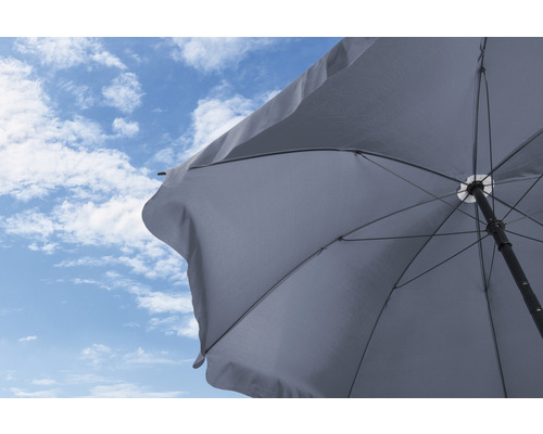 Otevřený slunečník na pozadí modré oblohy s mraky