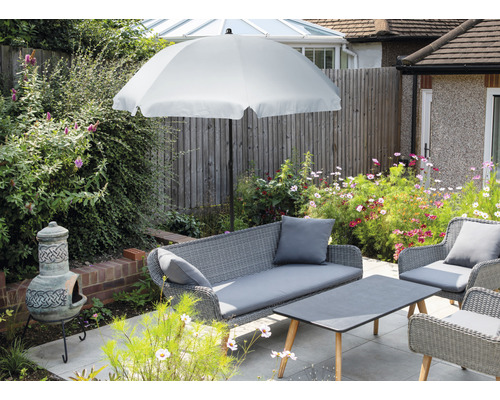 Zahradní nábytek se slunečníkem, pohovkou, křesly a stolem na terase.