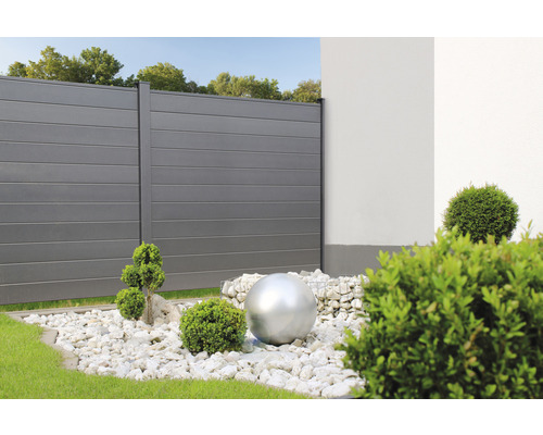 Scéna se zástěnou soukromí, okrasným štěrkem a nerezovou koulí do zahrady