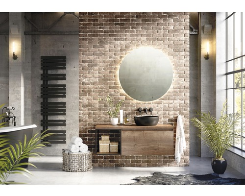 Koupelna s umyvadlem, zrcadlem, ohřívačem ručníků a dekorací před cihlovou zdí