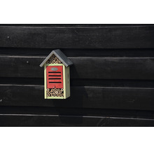 Hmyzí hotel s bambusovými trubkami a střechou na dřevěné stěně