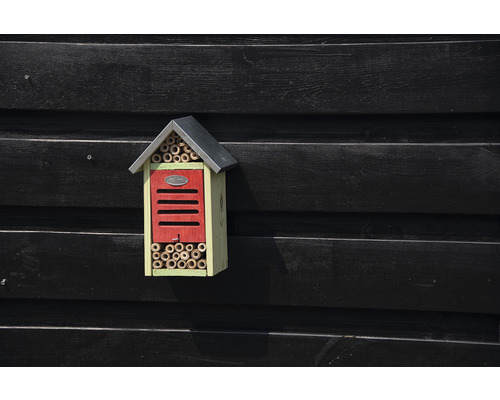 Hmyzí hotel s bambusovými trubkami a střechou na dřevěné stěně