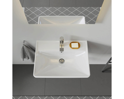 Pohled shora na umyvadlo s kohoutkem, mýdlem, ručníkem a zrcadlem v koupelně