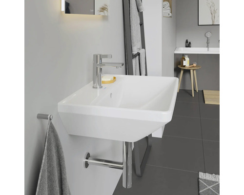 Moderní koupelna s bílým umyvadlem na stěnu, baterií a držákem na ručníky