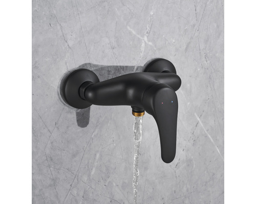 Černá sprchová baterie s tekoucí vodou na stěně