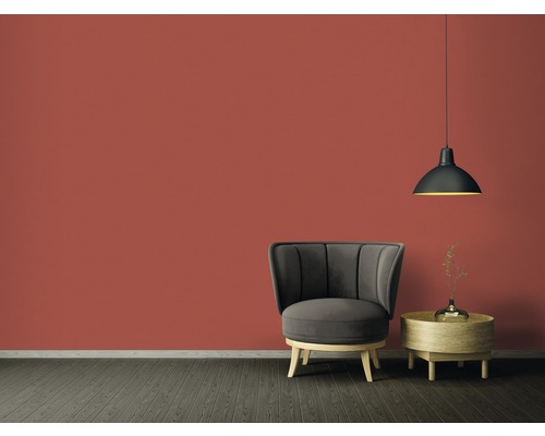Obývací pokoj s křeslem, odkládacím stolkem a závěsnou lampou před barevnou stěnou