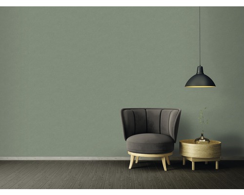 Ukázka uspořádání s křeslem, odkládacím stolkem a závěsným svítidlem před zelenou stěnou