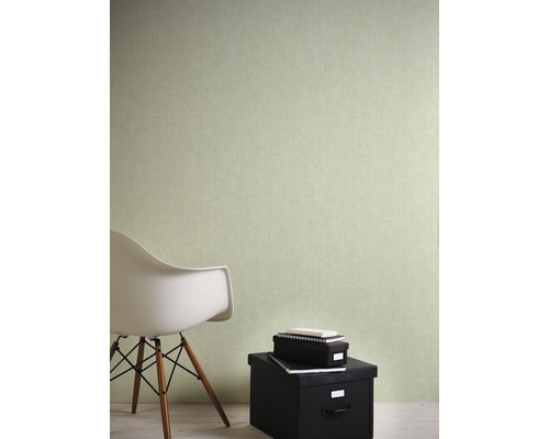 Pohled na místnost s jednobarevnou tapetou, židlí a úložnými boxy