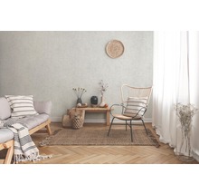 Obývací pokoj s pohovkou, židlí a kobercem na parketové podlaze před strukturovanou stěnou